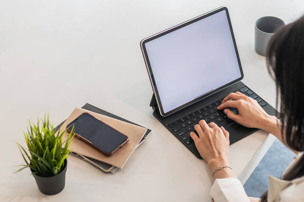 Uma mulher de negócios está usando um laptop para se comunicar e verificar o trabalho de casa on-line, porque ela está começando um negócio que pode encomendar e verificar de qualquer lugar on-line. - Foto, Imagem