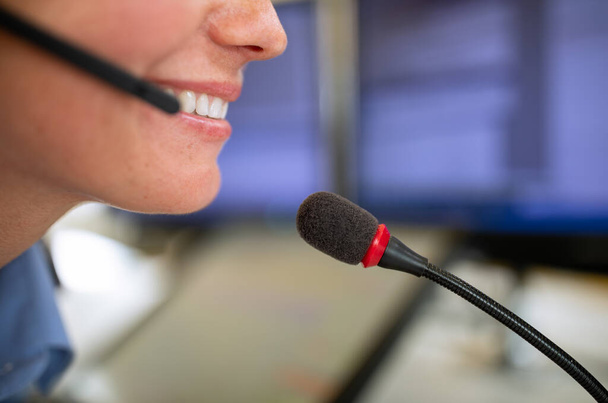 Call centre  employee communicating over phone using an external microphone for better sounf and ergonomics - Photo, Image