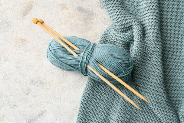 Knitting yarn, needles and plaid on grunge background, closeup - Photo, image
