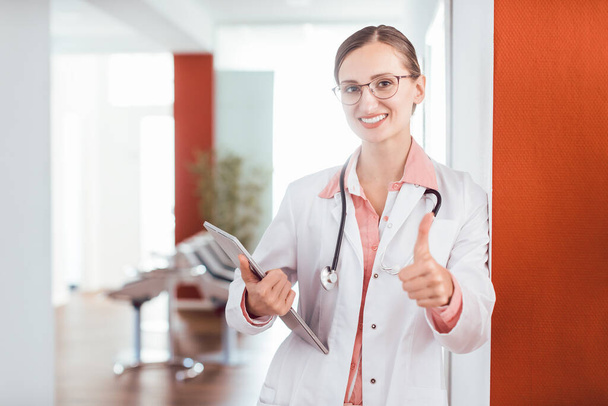 Beautiful Doctor woman in her practice giving a thumbs up - 写真・画像