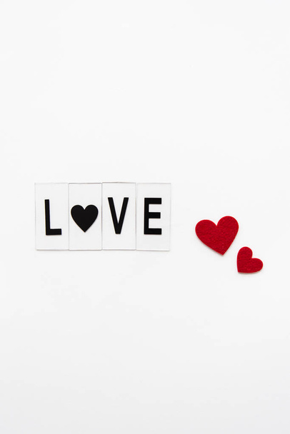 Beautiful inscription love on a white background, small red hearts. Postcard - Fotó, kép