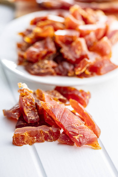 dried tomatoes in a white plate on a wooden background - 写真・画像