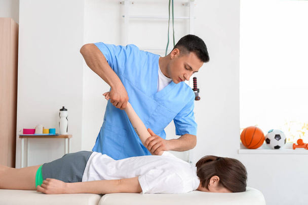 Physiotherapist working with patient in rehabilitation center - Foto, imagen