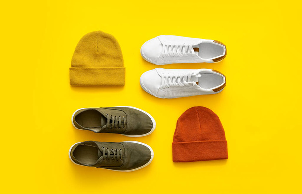Stylish shoes and knitted hats on color background - Photo, Image