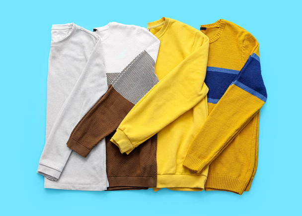 Stylish sweaters on color background - Фото, зображення