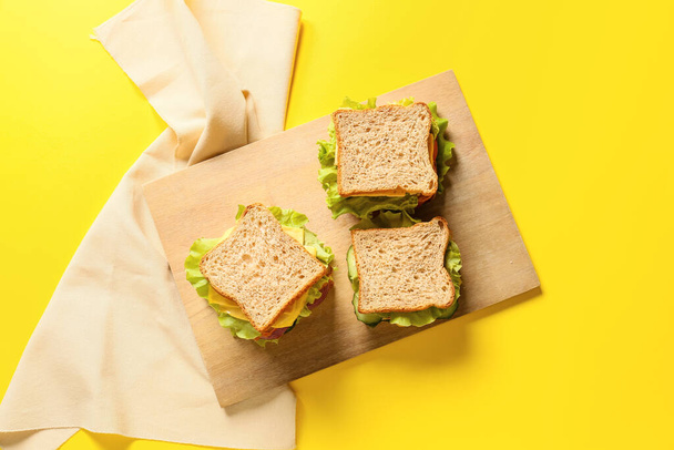 Placa com sanduíches saborosos no fundo de cor - Foto, Imagem
