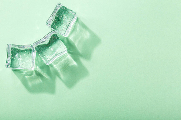 green ice cubes on a blue background - Foto, afbeelding