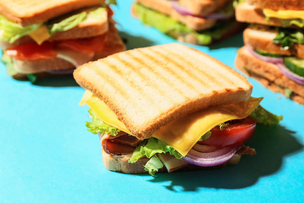 Sabrosos sándwiches sobre fondo de color, primer plano - Foto, imagen