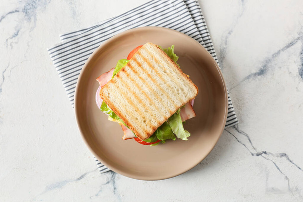 Plate with tasty sandwich on light background - Foto, Imagen