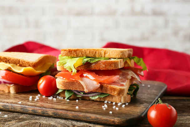 Board with tasty sandwiches on table, closeup - Фото, изображение