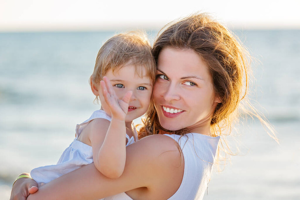 Portrait of mother and little daughter on the sea beach in Greece - Photo, Image