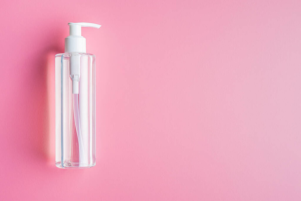 Coronavirus prevention hand sanitizer gel in bottle. Hand disinfectant gel on pink background. Top view. - Zdjęcie, obraz