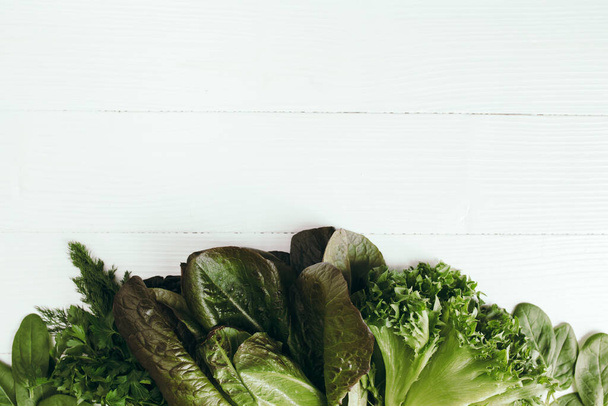 Piatto giaceva con foglie fresche di insalata verde di spinaci, lattuga, romana su sfondo bianco. Sano concetto di alimentazione vegetariana. Foto di alta qualità - Foto, immagini