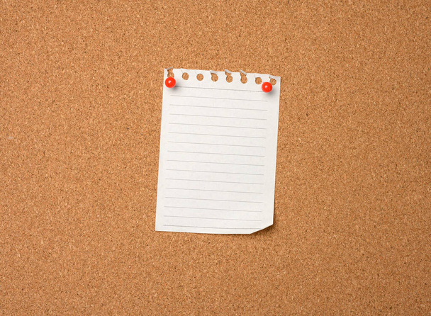 blank sheet of paper pinned by button on brown cork board, copy space - Foto, Imagen
