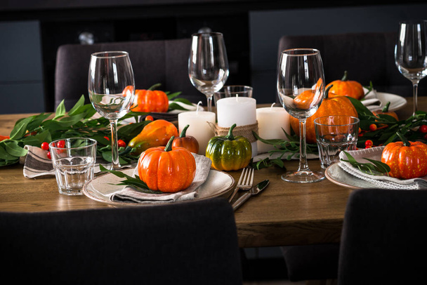 Jesienny stół z talerzem, dynią i świecami. - Zdjęcie, obraz