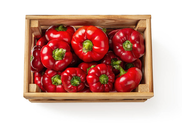 Red peppers ratunda gogoshar in a wooden crate isolated on a white background. Fresh sweet bell peppers in a wooden box. Vegetables for vegetarian healthy eating. High quality image. Top view. - Foto, Bild