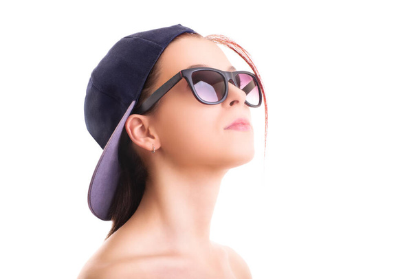 Close up shot of a beautiful stylish girl with backwards snapback cap and sunglasses, isolated on white background. Cool concept. - Φωτογραφία, εικόνα