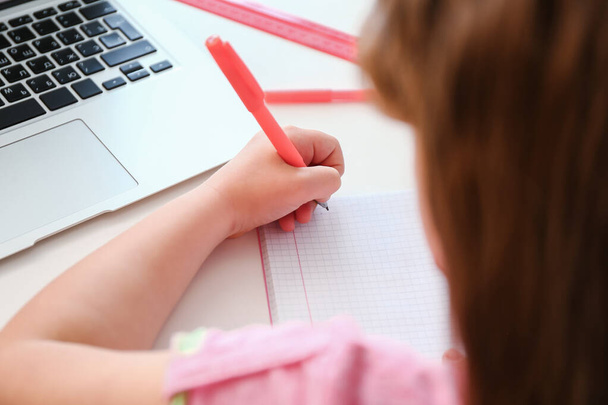 Little girl writing in notebook at home, closeup - Photo, Image