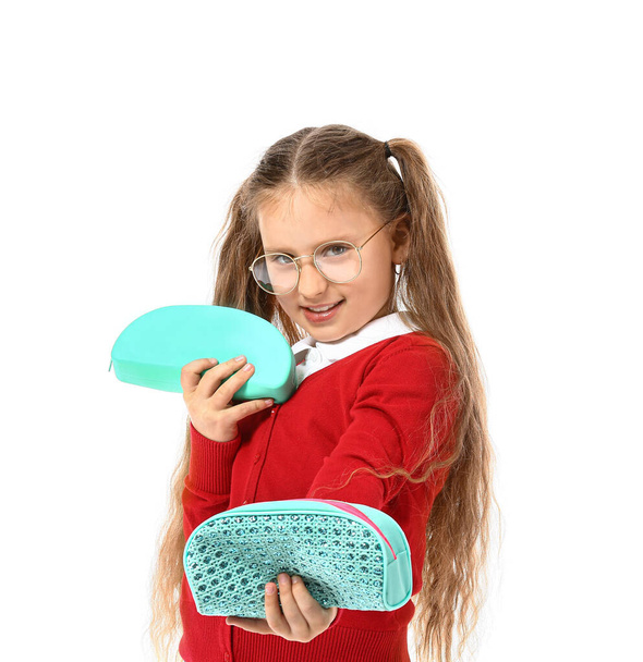 Little girl with pencil cases on white background - Photo, Image