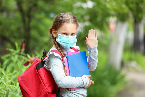 Kisiskolás lány orvosi maszkban a szabadban. - Fotó, kép