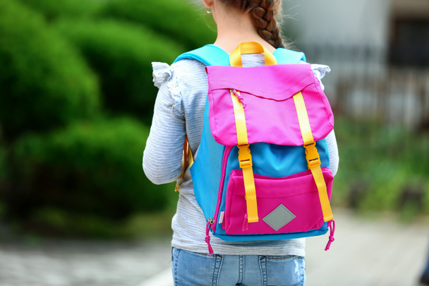 Маленька школярка з рюкзаком на відкритому повітрі
 - Фото, зображення