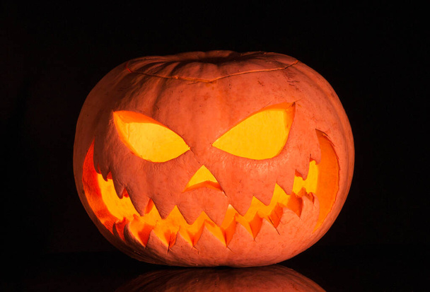 halloween pumpkin with a glowing candle on a black background - Foto, Imagem