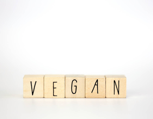 Vegan and hashtag written with wooden cubes and nature decoration isolated on white background with copy space, vegan,vegetarian,health concept background modern design natural style close up - Photo, Image