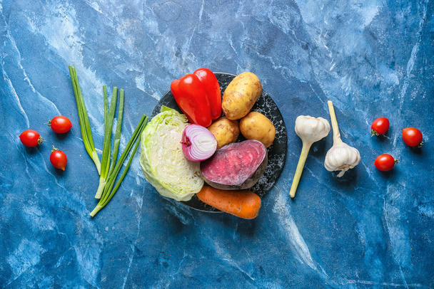 Bord met ingrediënten voor het bereiden van smakelijke borsjt op kleur achtergrond - Foto, afbeelding