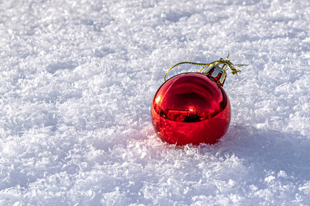 une boule de Noël rouge sur neige blanche - Photo, image