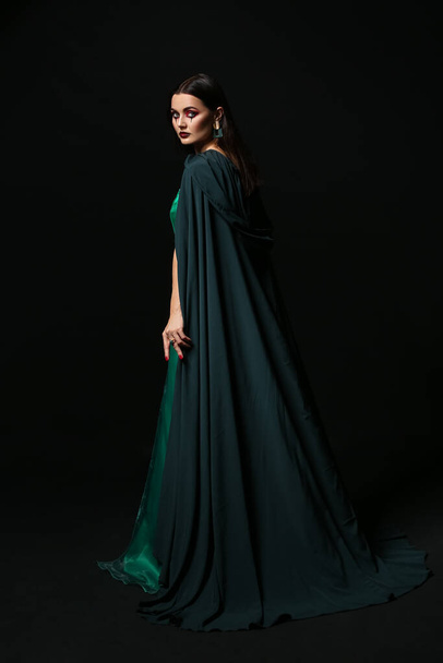 Hermosa mujer vestida de bruja para Halloween sobre fondo oscuro - Foto, Imagen