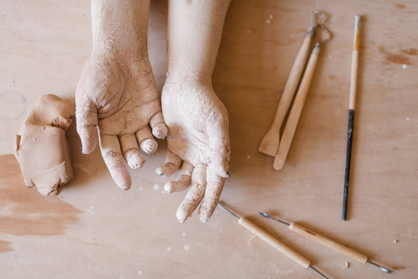Female potter hands covered with dried clay, pottery workshop. Woman molding a bowl. Handmade ceramic art, tableware making - Foto, Bild