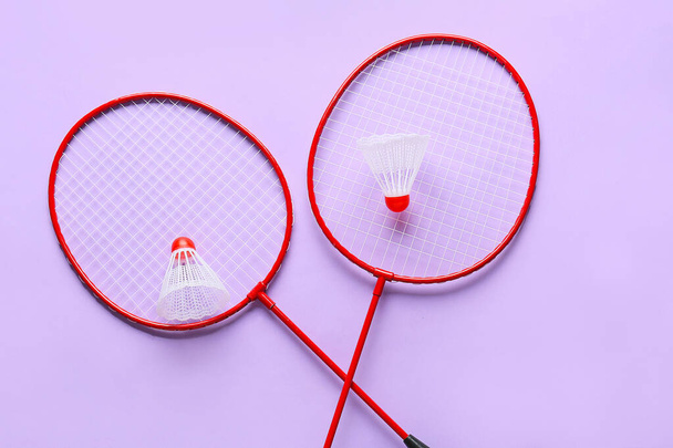 Badminton rackets and shuttlecocks on color background - Фото, изображение