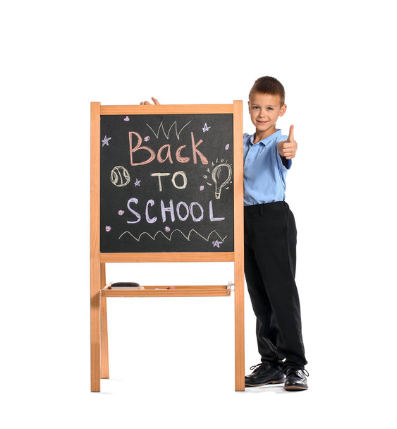 Aranyos iskolás fiú táblával mutatja hüvelykujj-up fehér háttér - Fotó, kép