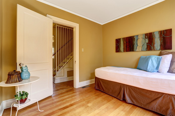 απλή υπνοδωμάτιο με μονό κρεβάτι στο ζωηρόχρωμη κλινοστρωμνή - Φωτογραφία, εικόνα