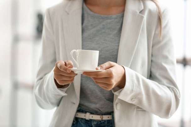 Young woman having coffee break in office, closeup - Foto, Imagen