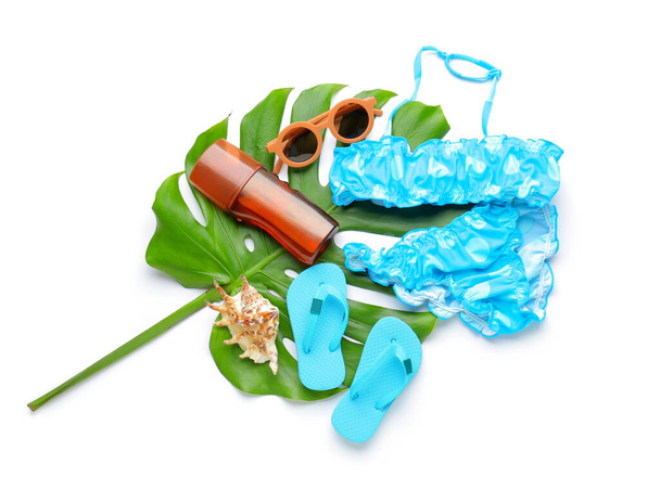 Skład z akcesoriami plażowymi dla dzieci, stylowy strój kąpielowy, butelka kremu do opalania i liść palmowy na białym tle - Zdjęcie, obraz