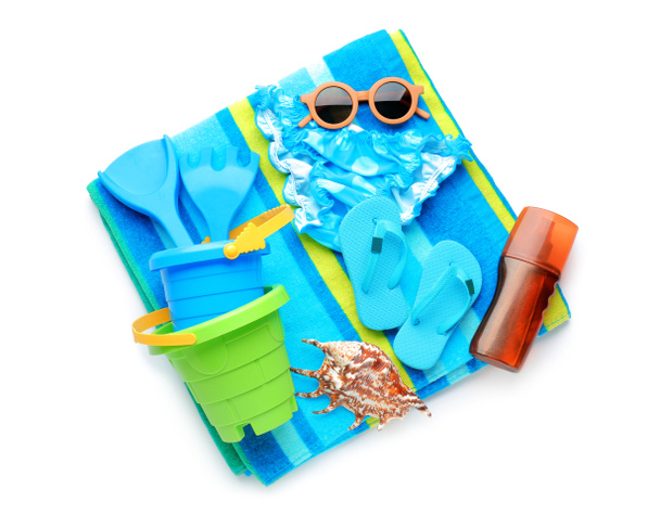 Set Strandzubehör für Kinder, stylischer Badeanzug und eine Flasche Sonnencreme auf weißem Hintergrund - Foto, Bild