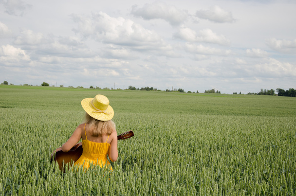 Country woman in dress play guitar wheat field  - Photo, Image