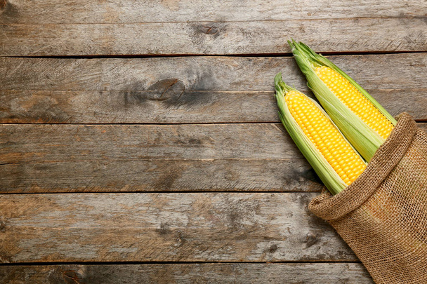 Tuoreet maissintähkät säkissä puupohjalla, lähikuva - Valokuva, kuva