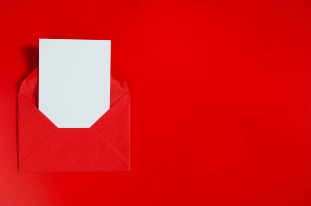 Greeting card for Valentine's Day, Woman's Day and Mother's Day. Red envelope with blank white paper. Mockup of love letter. Top view with space for your text. Flat lay - Fotografie, Obrázek