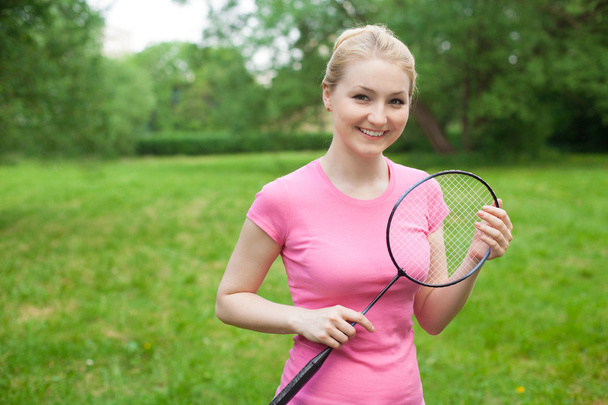 blonde girl holding tennis -racket wearing pinck t-shirt  - Фото, зображення