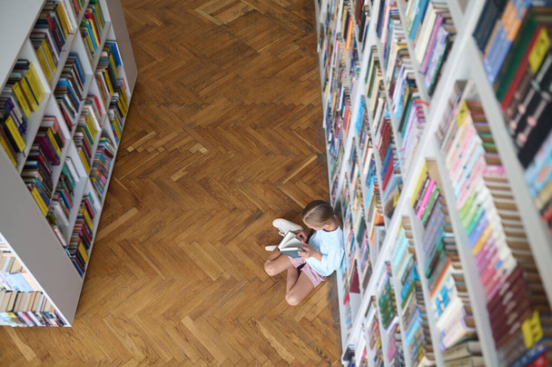 Young girl flipping through the pages of a book - Photo, image