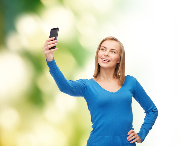 woman taking self picture with smartphone camera - Foto, Bild