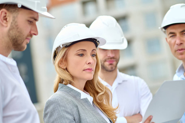 Concentrated blonde supervisor performing a construction site inspection - Photo, image