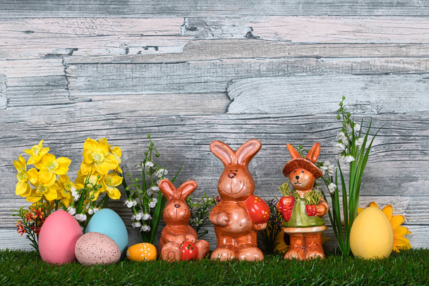 easter eggs and flowers on wooden background - Foto, afbeelding