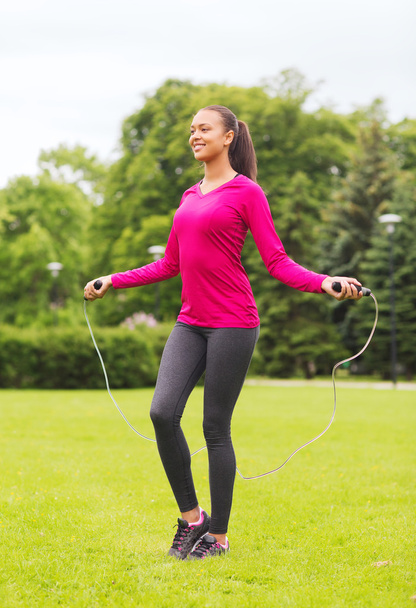 smiling woman exercising with jump-rope outdoors - Fotografie, Obrázek