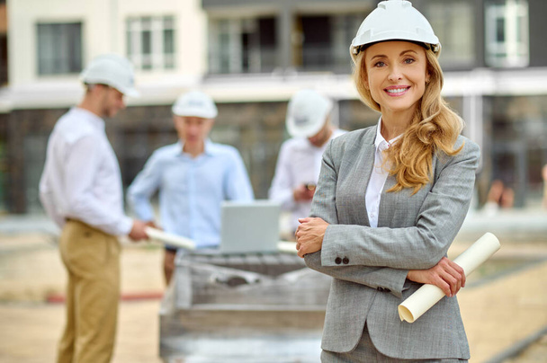 Joyous determined female construction manager in a hardhat standing outdoors - Photo, Image