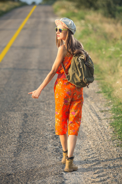Beautiful young woman traveling alon a road - 写真・画像