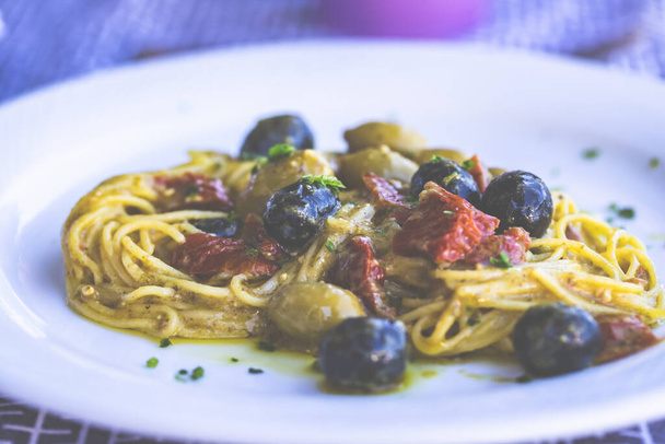 Delicious spaghetti, vegetarian with dried tomatoes, olives and fresh herbs. - Foto, Imagem