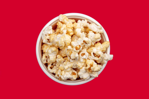 Crunchy Popcorn on red background - Valokuva, kuva